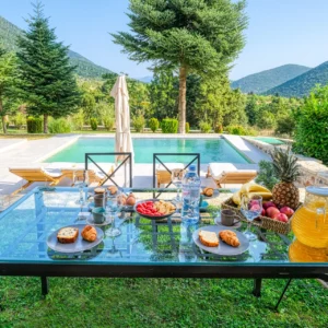 Breakfast table beside the pool with mountain views at Villa Mainalis in Arcadia