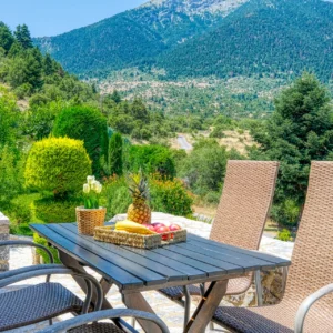 Outdoor dining terrace overlooking the mountains at Villa Mainalis