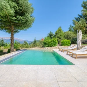 Private swimming pool with Mount Mainalo rising beyond the garden at Villa Mainalis