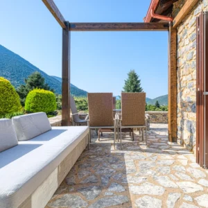 Covered outdoor lounge terrace with mountain views at Villa Mainalis