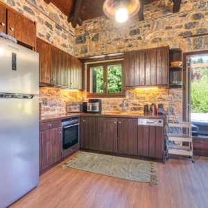 Fully equipped kitchen with wooden cabinetry at Villa Mainalis