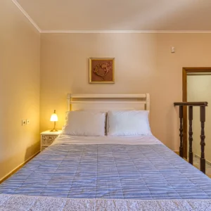 Bedroom 2 with a double bed and internal stair access to Bedroom 5 at Villa Mainalis