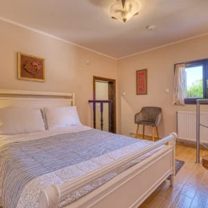 Bedroom 2 with a double bed and internal stairs leading down to Bedroom 5 at Villa Mainalis
