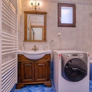 Bathroom with washbasin, shower area and washing machine at Villa Mainalis