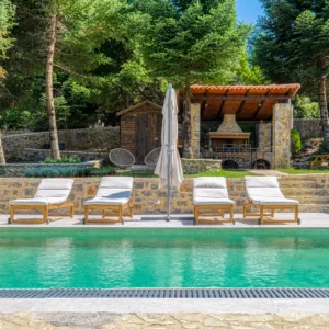 Private pool with sun loungers and covered barbecue area at Villa Mainalis