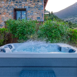 Outdoor hot tub with mountain and garden views at Villa Mainalis