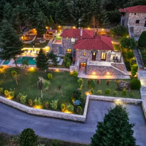 Aerial twilight view of Villa Mainalis with illuminated gardens and pool